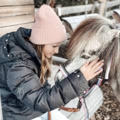 Mädchen kuschelt mit Pony