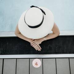 Frau mit Hut im Pool