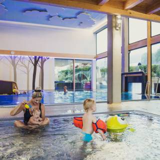 Mutter spielt mit Kindern im Babypool