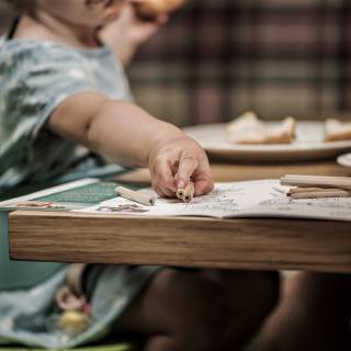 Kind im Restaurant beim essen und malen