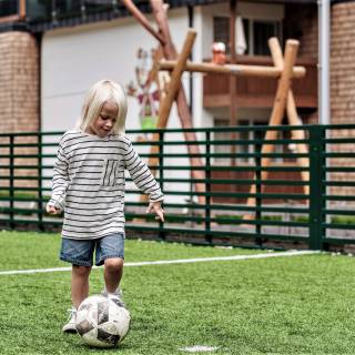 Junge spielt Fußball im Mia Alpina
