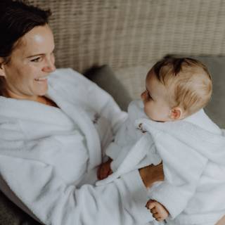 Mutter mit Baby im Bademantel