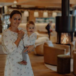 Mutter mit Baby auf dem Arm in der Rezeption