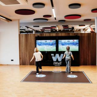 Zwei Kinder spielen an der Videoplaywall in der Area500