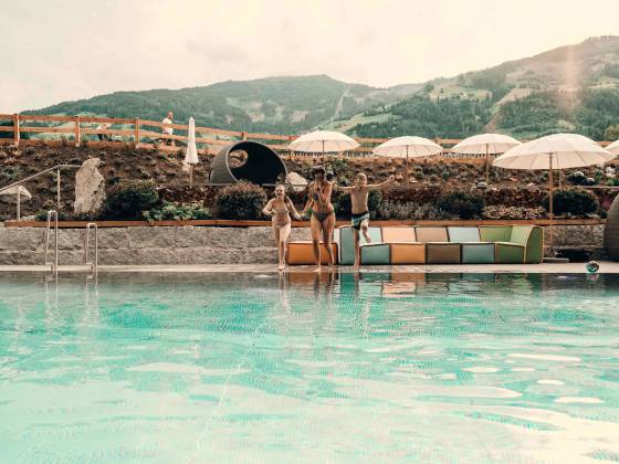 Mutter mit zwei Kindern springt in den Outdoorpool