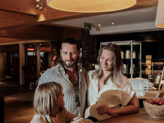 Familie steht an der Rezeption des Mia Alpina