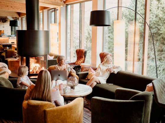 Familie sitzt in der Lounge und trinkt Heißgetränke