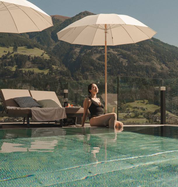 Frau sitzt am Panoramapool