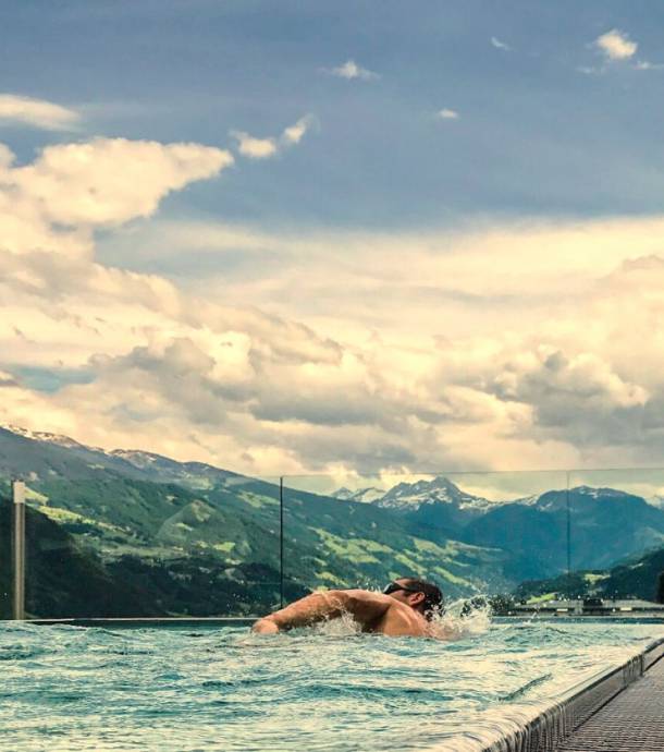 Mann schiwimmt im Infinity-Skypool im Mia Alpina
