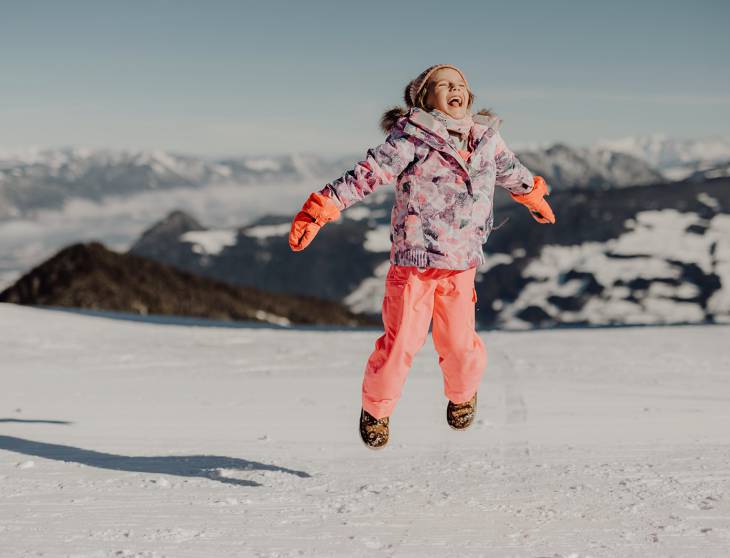 Mädchen springt im Schnee