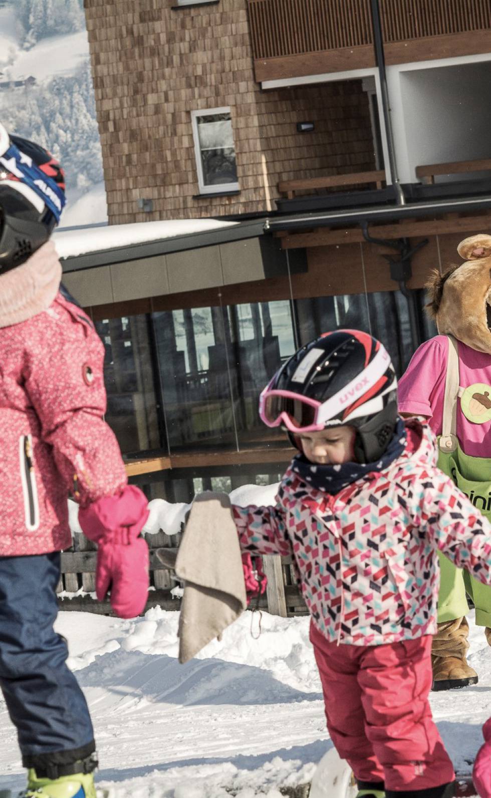 Maskottchen Alpini bei den Kindern in der Skischule