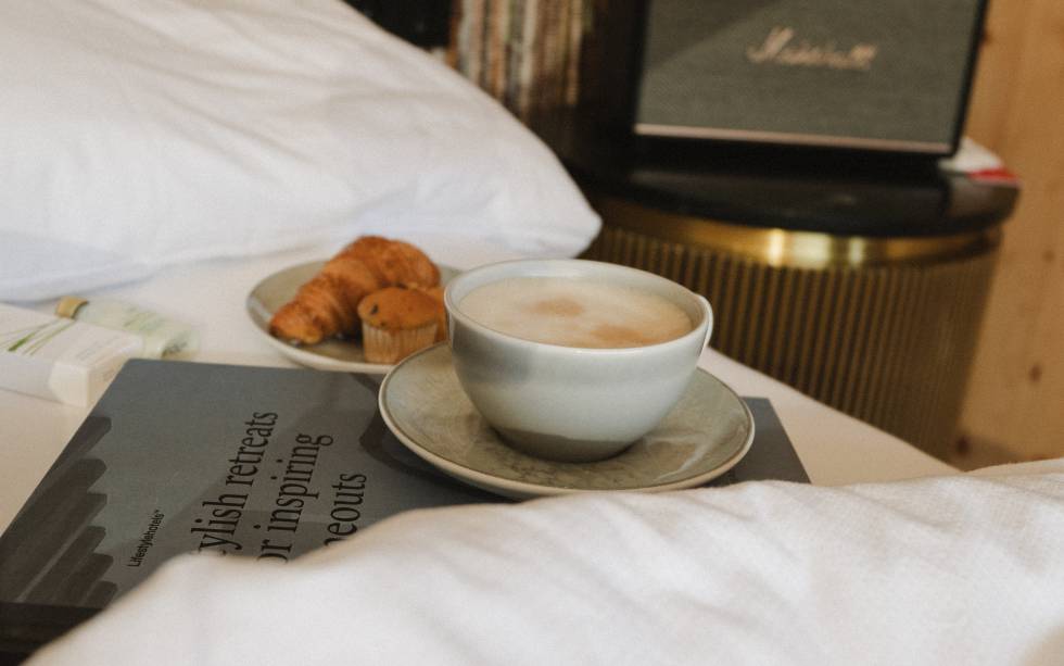 Capuccino und Gebäck auf dem Hotelbett