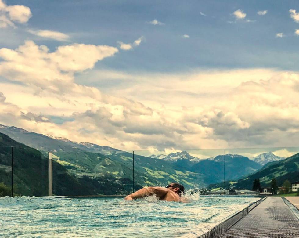 Mann schwimmt im Panoramapool 
