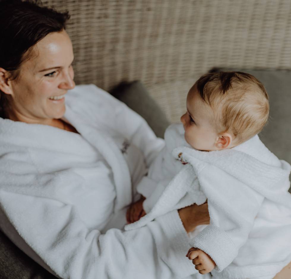 Mutter mit Baby im Bademantel